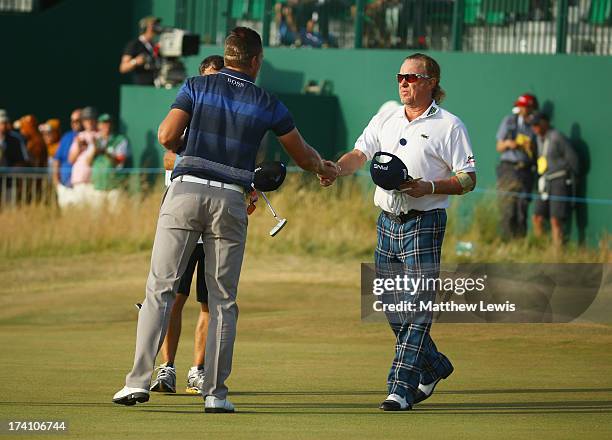 Miguel Angel Jimenez of Spain shakes hands with Henrik Stenson of Sweden after finishing the third round of the 142nd Open Championship at Muirfield...