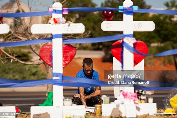 Community members erect twelve crosses at a remembrance ceremony July 20, 2013 in Aurora, Colorado. The ceremony marks the one one-year anniversary...