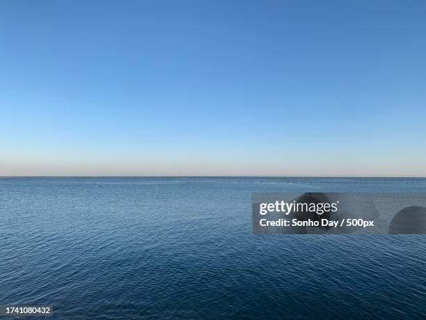 scenic view of sea against clear blue sky - sonho stock-fotos und bilder