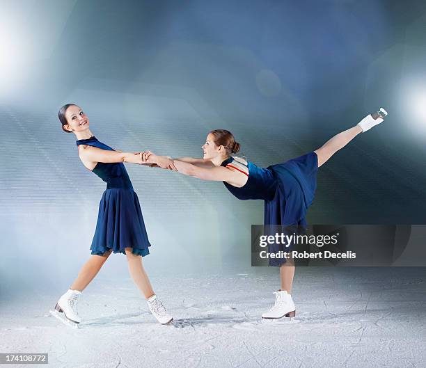 two skaters, one supporting the other. - figure skating woman stock pictures, royalty-free photos & images