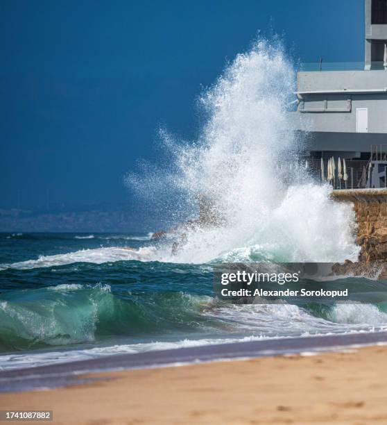 ocean waves roll onto the shore and crash against the rocks. - klippe fotografías e imágenes de stock