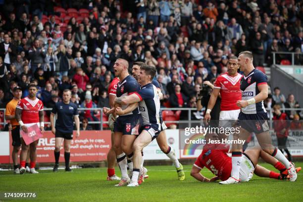 Mikey Lewis of England celebrates with teammate John Bateman after scoring their sides second try during the Autumn Test Series match between England...