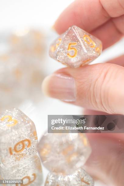 woman's hand holding polyhedral dice - dungeon stock pictures, royalty-free photos & images