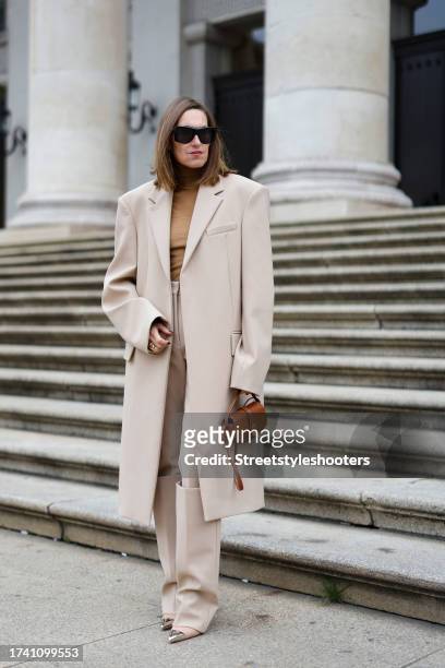 Influencer Annette Weber, wearing a beige coat by Sportmax, beige pants by Sportmax, a beige pullover by Max Mara, a brown bag by Celine, beige pumps...