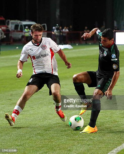 Ailton of FC Terek Grozny is challenged by Makhach Gadzhiev of FC Amkar Perm during the Russian Premier League match between FC Terek Grozny and FC...
