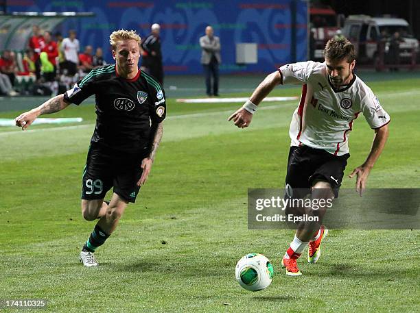 Jonathan Legear of FC Terek Grozny is challenged by Makhach Gadzhiev of FC Amkar Perm during the Russian Premier League match between FC Terek Grozny...
