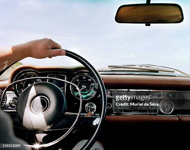 hand on steering wheel - steering wheel foto e immagini stock