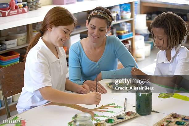 children and their teacher in an art lesson - art class stock pictures, royalty-free photos & images