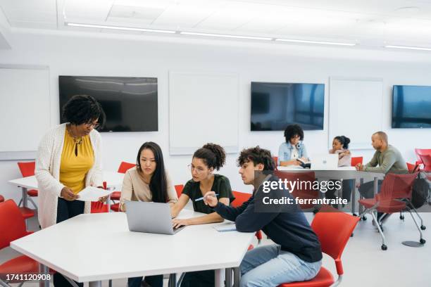 teacher helping university students in classroom - classroom wide angle stock pictures, royalty-free photos & images