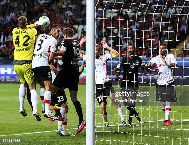 Oleg Ivanov of FC Terek Grozny is challenged by Sergei Narubin and Petar Zanev of FC Amkar Perm during the Russian Premier League match between FC...