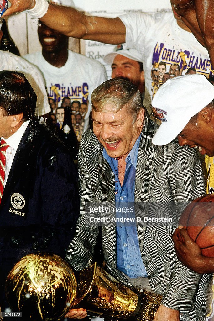Jerry Buss celebrates while holding trophy