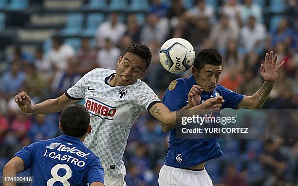 Cruz Azul's midfielder Israel Castro observes as teammate Rogelio Chavez jumps to head the balll with Monterrey's midfielder Jesus Eduardo Zavala...
