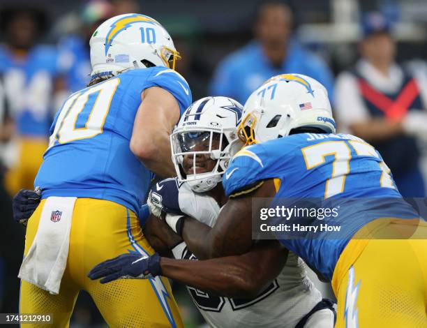 Dorance Armstrong of the Dallas Cowboys fights off Zion Johnson of the Los Angeles Chargers to get to Justin Herbert during a 20-17 win over the...