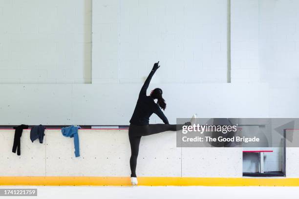 rear view of figure skater stretching at ice rink - figure skating lift stock pictures, royalty-free photos & images