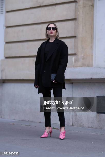 Emy Venturini wears black jeans from Redone, a black top from Cos, a black oversize blazer jacket from Frankie Shop, vintage sunglasses, a Chanel...