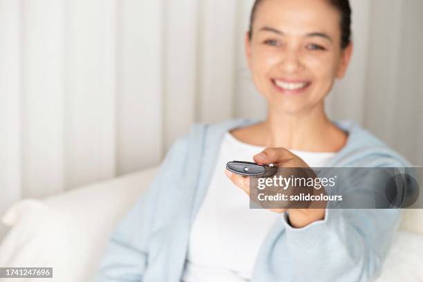 woman looking to tv at home - zapping stock pictures, royalty-free photos & images