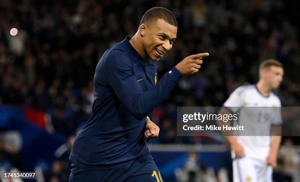 Kylian Mbappe of France celebrates after scoring the team's third goal from the penalty spot during the International Friendly between France and...