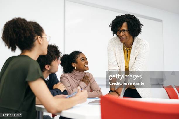 teacher helping university students in classroom - lecturer stock pictures, royalty-free photos & images