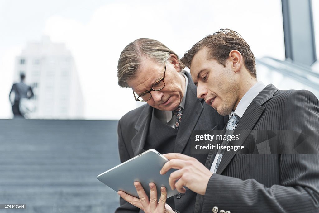 Businessmen looking at digital tablet