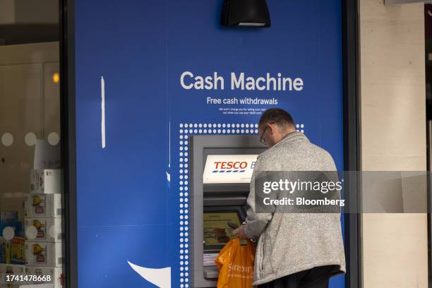 Customer uses a Tesco Bank automated teller machine , operated by Tesco Plc, in Guildford, UK, on Monday, Oct. 23, 2023. Tesco has started the...