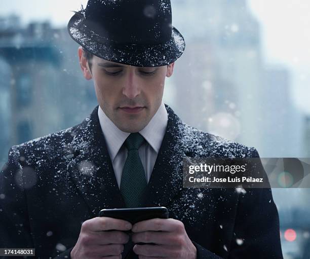 business man texting in the snow - hat and suit stock pictures, royalty-free photos & images