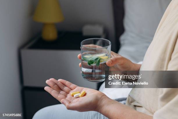 woman taking her vitamins and supplements, variety of pills and capsules in hands - antioxidant pill stock pictures, royalty-free photos & images