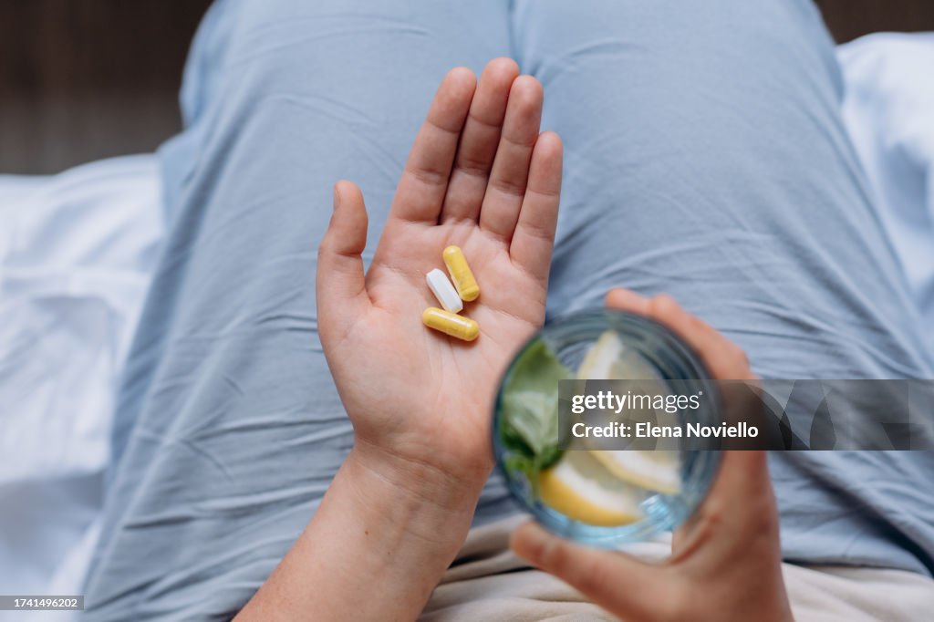 Woman taking her vitamins and supplements, Variety of pills and capsules in hands
