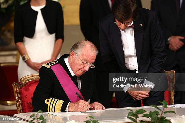 King Albert II of Belgium signs the abdication papers while being watched by Prime Minister Elio Di Rupoa at the Abdication Ceremony Of King Albert...