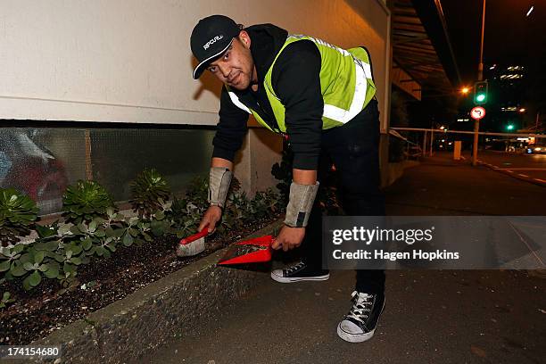 Glazier, James Harrison of Hamilton, sweeps up broken glass outside Hume House Apatments on the Terrace after fixing earthquake damaged windows on...