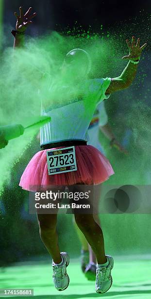 Competitors run through the green colour throw area during the Color Run on July 21, 2013 in Cologne, Germany.