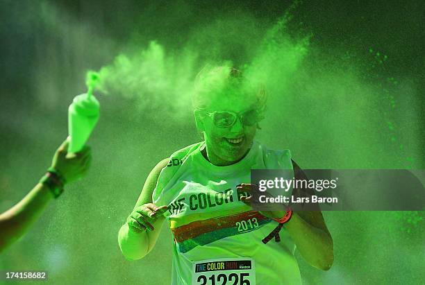 Competitors run through the green colour throw area during the Color Run on July 21, 2013 in Cologne, Germany.