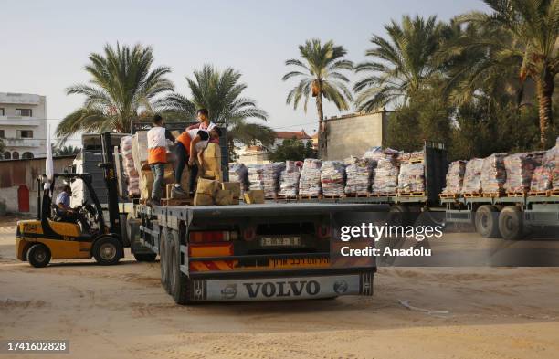 Members of Palestine Red Crescent Society organize supplies of humanitarian aid for Palestinians sent by World Health Organization , after entering...