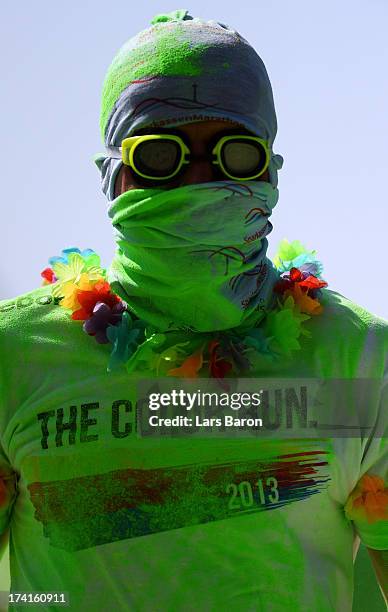 Competitors run through the green colour throw area during the Color Run on July 21, 2013 in Cologne, Germany.