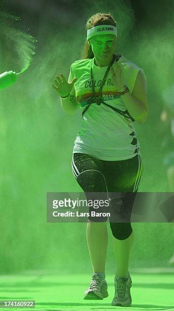 Competitors run through the green colour throw area during the Color Run on July 21, 2013 in Cologne, Germany.