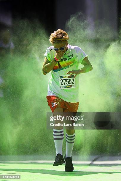 Competitors run through the green colour throw area during the Color Run on July 21, 2013 in Cologne, Germany.