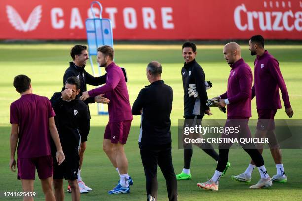Sevilla's Uruguayan coach Diego Alonso welcomes Sevilla's Croatian midfielder Ivan Rakitic and the rest of teammates as they arrive for a training...