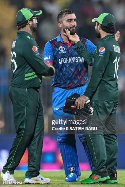 Pakistan's Mohammad Rizwan greets Afghanistan's captain Hashmatullah Shahidi as his teammate Imam-ul-Haq watches at the end of the 2023 ICC Men's...