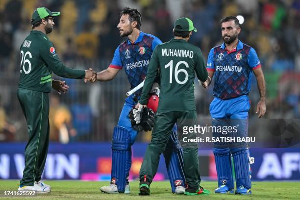Afghanistan's captain Hashmatullah Shahidi and his teammate Rahmat Shah shake hands with Pakistan's players at the end of the 2023 ICC Men's Cricket...