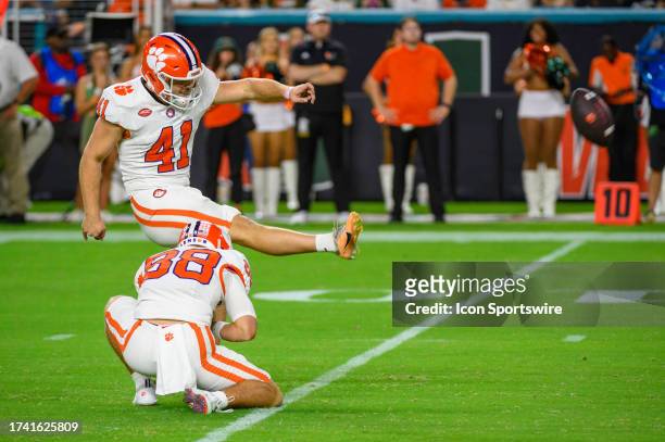 Clemson wide receiver Clay Swinney holds the ball as Clemson kicker Jonathan Weitz kicks for an extra point during the college football game between...