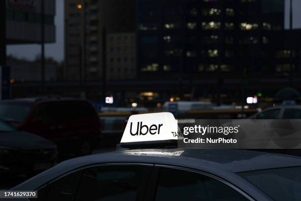 Uber taxi sign is seen on a car in Warsaw, Poland on October 20, 2023.