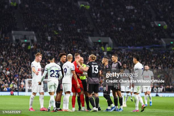 Referee Anthony Taylor is swarmed by players from both sides during the Premier League match between Tottenham Hotspur and Fulham FC at Tottenham...