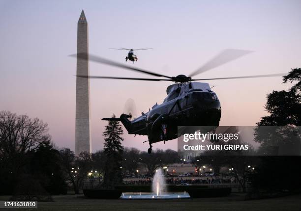 The Marine One helicopter with US President Barack Obama arrives at the White House as the back-up helicopter flies past the Washington monument in...