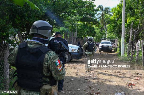 Security forces inspect the area where at least 11 police officers were killed in an ambush by criminal groups in Coyuca de Benitez, state of...