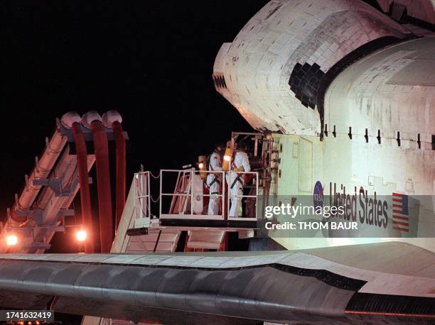 The Space Shuttle Discovery has an umbilical carrier attached by members of the landing team moments after landing at the Kennedy Space Center 27...