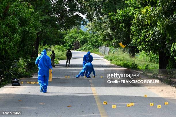 Forensics recover evidence at the site where at least 11 police officers were killed in an ambush by unidentified attackers in Coyuca de Benitez,...