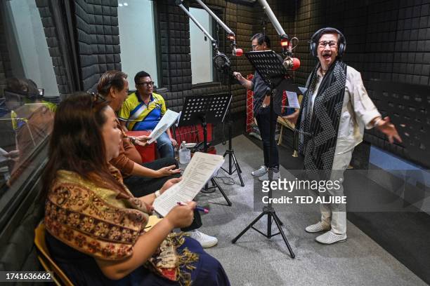 This photo taken on July 6, 2023 shows voice actors recording their part for a radio drama at a studio of a radio station in Manila. Radio dramas...