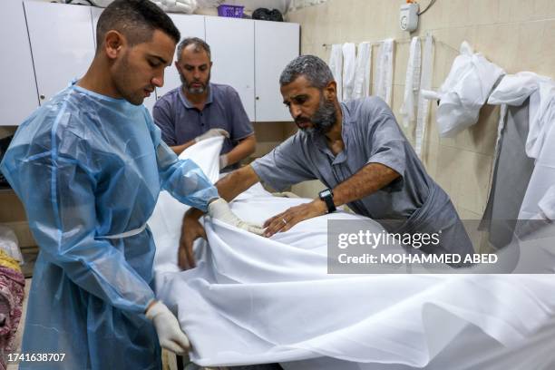 Graphic content / Medics wrap the body of a Palestinian killed in an Israeli strike at Najjar hospital in Rafah on the southern Gaza Strip on October...