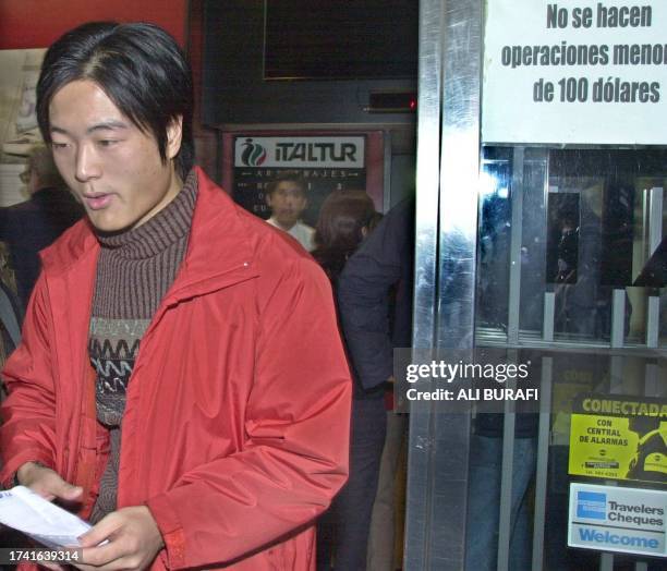 An syno-argentinian citizen leaves the foreign exchange in the fancial zone of Buenos Aires 23 May 2002. Groups of Asians operate in the financial...