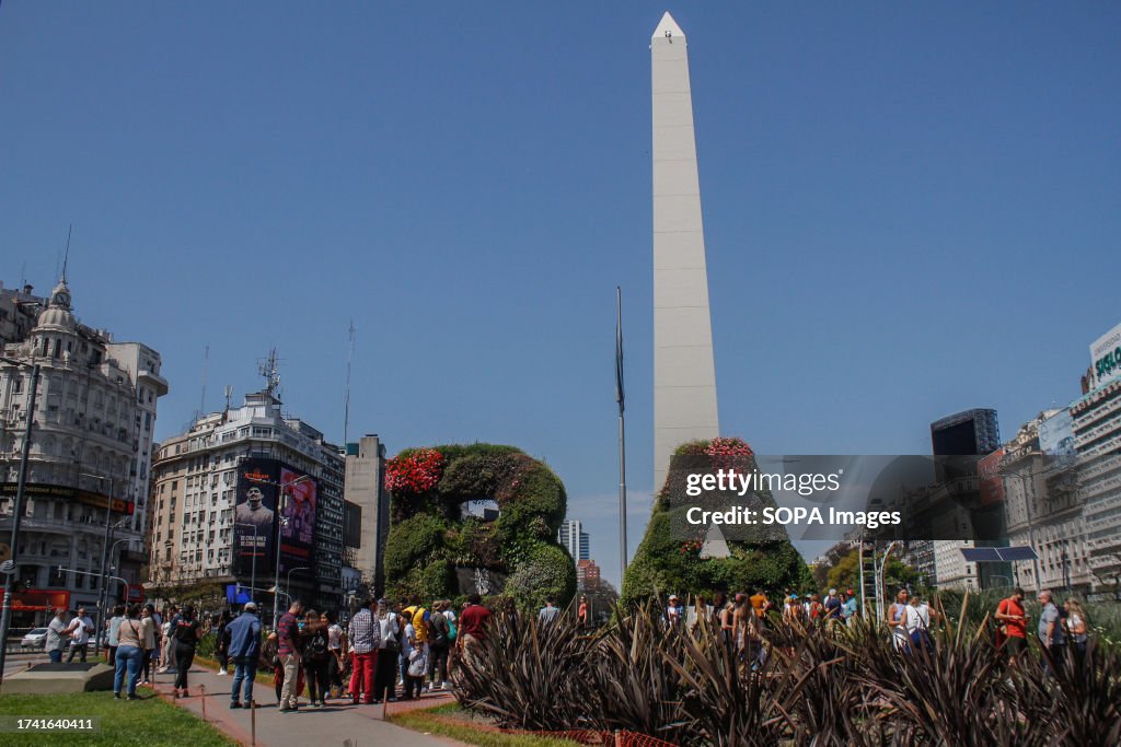 People walk by the Obelisk of Buenos Aires, a historical...