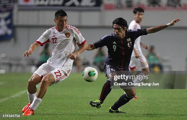 Masato Kudo of Japan and Yu Dabao of China compete for the ball during the EAFF East Asian Cup match between Japan and China at Seoul World Cup...